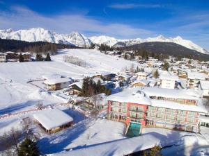 a town covered in snow with mountains in the background at Das Hotel Eden - Das Aktiv- & Wohlfühlhotel in Tirol auf 1200m Höhe in Seefeld in Tirol