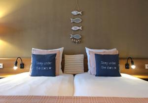 a bedroom with a bed with two pillows and fish hooks at Hotel Truida in Vlissingen