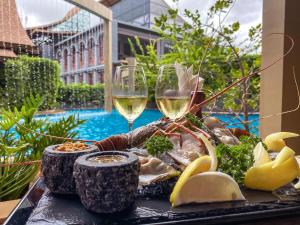 a tray of food and wine glasses on a table at Aurico Kata Resort & Spa - SHA Extra Plus in Kata Beach