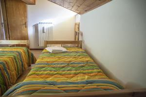 a bedroom with two beds in a room at Apartments Ospitalità Diffusa Borgate tra le Malghe in Falcade