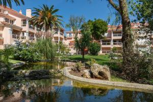 カスカイスにあるLuxury Colina Parkの建物の前に池がある庭園