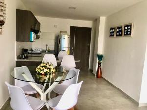 a dining room with a table and chairs in a kitchen at DEPARTAMENTO TOTALMENTE NUEVO, AMOBLADO Y DE LUJO EN TONSUPA in Tonsupa