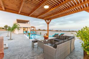an outdoor patio with a table and chairs and a pool at Dorieus Villa in Lakhania