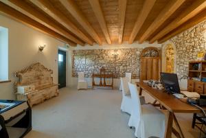 um quarto com uma mesa e cadeiras e uma parede de pedra em La Fonte degli Dei em Negrar