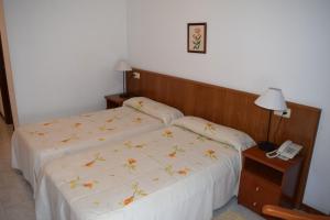 a hotel room with two beds and a telephone at Hotel Restaurante Xaneiro in Melide