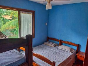 a bedroom with blue walls and a bed and a window at Feriasmares in Ilhéus