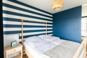 a bedroom with blue and white striped walls and a bed at Chill and Sun in Kołobrzeg