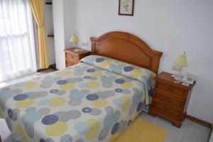 a bedroom with a bed and a night stand with two lamps at Hotel Restaurante Xaneiro in Melide