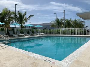 a swimming pool at a resort with chairs and umbrellas at Wyndham Garden Miami International Airport in Miami