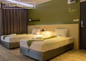 two beds in a hotel room with a sign at Thongmanee Hotel in Hat Yai