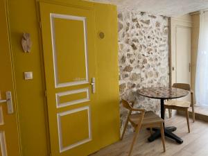 a room with a yellow door and a table at L'Atelier de Marie in Eyguières