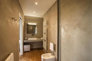 uma casa de banho com um lavatório e um WC. em Relais Villa del Borgo em Canelli