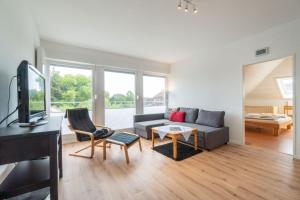 ein Wohnzimmer mit einem Sofa und einem TV in der Unterkunft Ferienhaus Butenbörkumer in Borkum