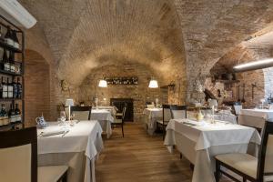 restauracja z białymi stołami i krzesłami w pokoju w obiekcie Asisium Boutique Hotel w Asyżu