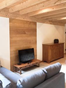 a living room with a couch and a flat screen tv at Les Billardes - le gite - Jura in Gizia