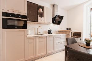 uma cozinha com armários brancos, um lavatório e uma mesa em Top Center-Apartment - Wohnung im Stadtzentrum in perfekter Lage & Balkon em Innsbruck