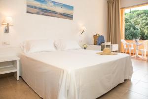 Un dormitorio con una gran cama blanca y una ventana en RVHotels Golf Costa Brava, en Santa Cristina d'Aro