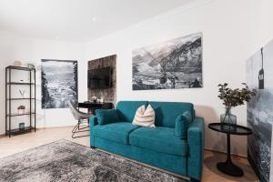 uma sala de estar com um sofá azul e uma mesa em Center-Apartment - Große Wohnung im Stadtzentrum in perfekter Lage em Innsbruck