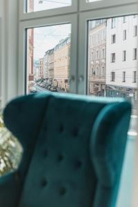 a chair in front of a window with a view of a city at Center-Apartment - Große Wohnung im Stadtzentrum in perfekter Lage in Innsbruck