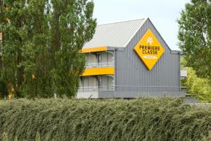 ein gelbes Schild an der Seite eines Gebäudes in der Unterkunft Premiere Classe Angers Beaucouzé in Beaucouzé