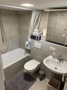 a bathroom with a toilet and a sink and a tub at Joanna Apartment - MA Casterfeld in Mannheim