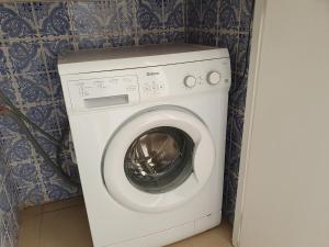 a white washing machine in a corner of a room at T1 Praiamar 3 Vista Fabulosa in Quarteira