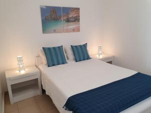 クアルテイラにあるT1 Praiamar 3 Vista Fabulosaのベッドルーム1室(ベッド1台、ナイトスタンド2台、ランプ2つ付)