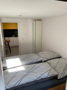 łóżko w sypialni z białą ścianą w obiekcie Joanna Apartment - MA Casterfeld w mieście Mannheim
