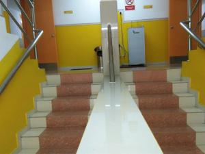 a set of stairs in a building with yellow walls at Hotel Abby IGB Tasek in Ipoh