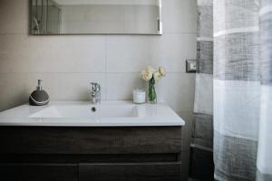 baño con lavabo y jarrón de flores en Altrentatre, en Voghera
