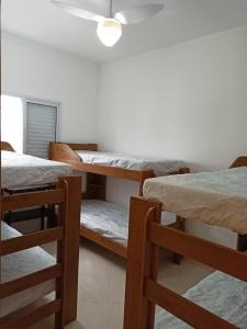 a room with three bunk beds and a ceiling at AP 71 COSTA VERDE PRAIA GRANDE in Praia Grande