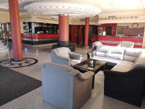 a lobby with couches and chairs in a building at Hotel Elegance in Belgrade