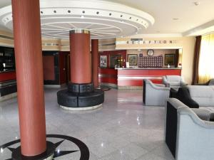 a lobby with red columns and a restaurant at Hotel Elegance in Belgrade