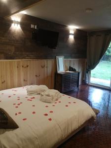 a bedroom with a bed with red rose petals on it at L'Imprévu in Bourisp