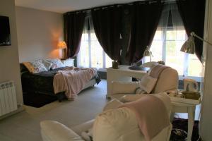 ein Wohnzimmer mit einem Bett und 2 Stühlen in der Unterkunft B&B Sallent in Sallent