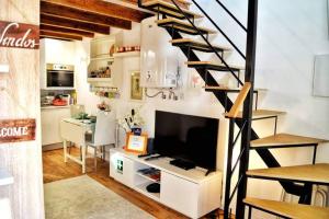 a living room with a staircase and a television at Casinha de Belém in Lisbon