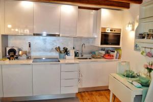 una cucina con mobili bianchi e un piano di lavoro di Casinha de Belém a Lisbona Altre 18 foto