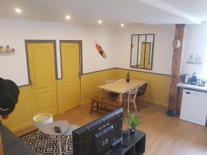 a living room with yellow doors and a table at F3 l'escale Conviviale - Villepinte Aéroport CDG - Parc Astérix - Paris in Mitry-Mory