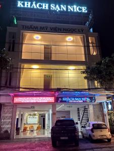 two cars parked in front of a building at night at Onhotel Nice Buôn Ma Thuột in Buon Ma Thuot