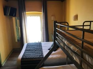 a bedroom with two bunk beds and a window at Hotel Magdeleine in Romans-sur-Isère