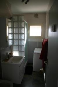La salle de bains est pourvue d'une baignoire, d'un lavabo et d'une fenêtre. dans l'établissement LES HORIZONS, à Camiers