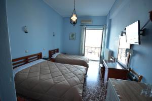 Habitación azul con 2 camas y mesa en Hotel Blue Sea en Tiros