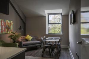 a living room with a table and a couch at Park Lane Aparthotel by Urban Space in Cardiff