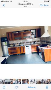 a kitchen with wooden cabinets and stainless steel appliances at Hotel - Hostel Marichka in Khmil'nyk