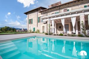 ein Haus mit einem Pool vor einem Gebäude in der Unterkunft Luxus Gardoncino in Manerba del Garda