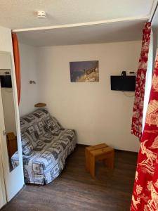 レ・メニュアールにあるAppartement Les Menuiresのベッド1台、ベッド1台、テーブルが備わる小さな客室です。