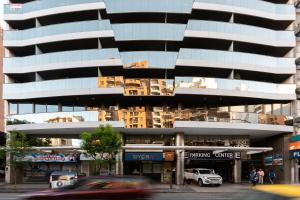 a tall building with cars parked in front of it at AT Suites in Córdoba