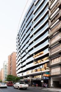 een hoog gebouw in een stadsstraat met auto's bij AT Suites in Cordoba
