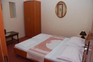a small bedroom with a bed and a mirror at Apartments Ismy in Ulcinj
