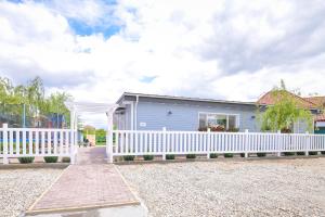 DomneştiにあるHappy Place - Casuta Albastraの青い家の前の白い柵